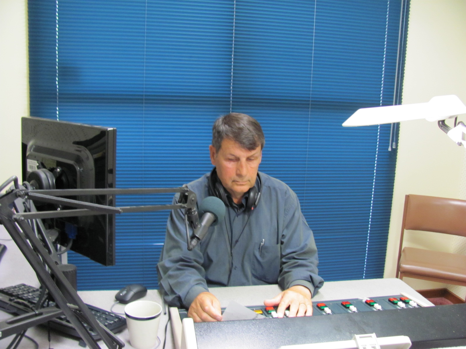 Volunteer sitting in a studio with a microphone in front of him